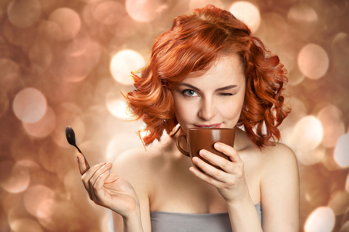 red haired woman sipping from teacup