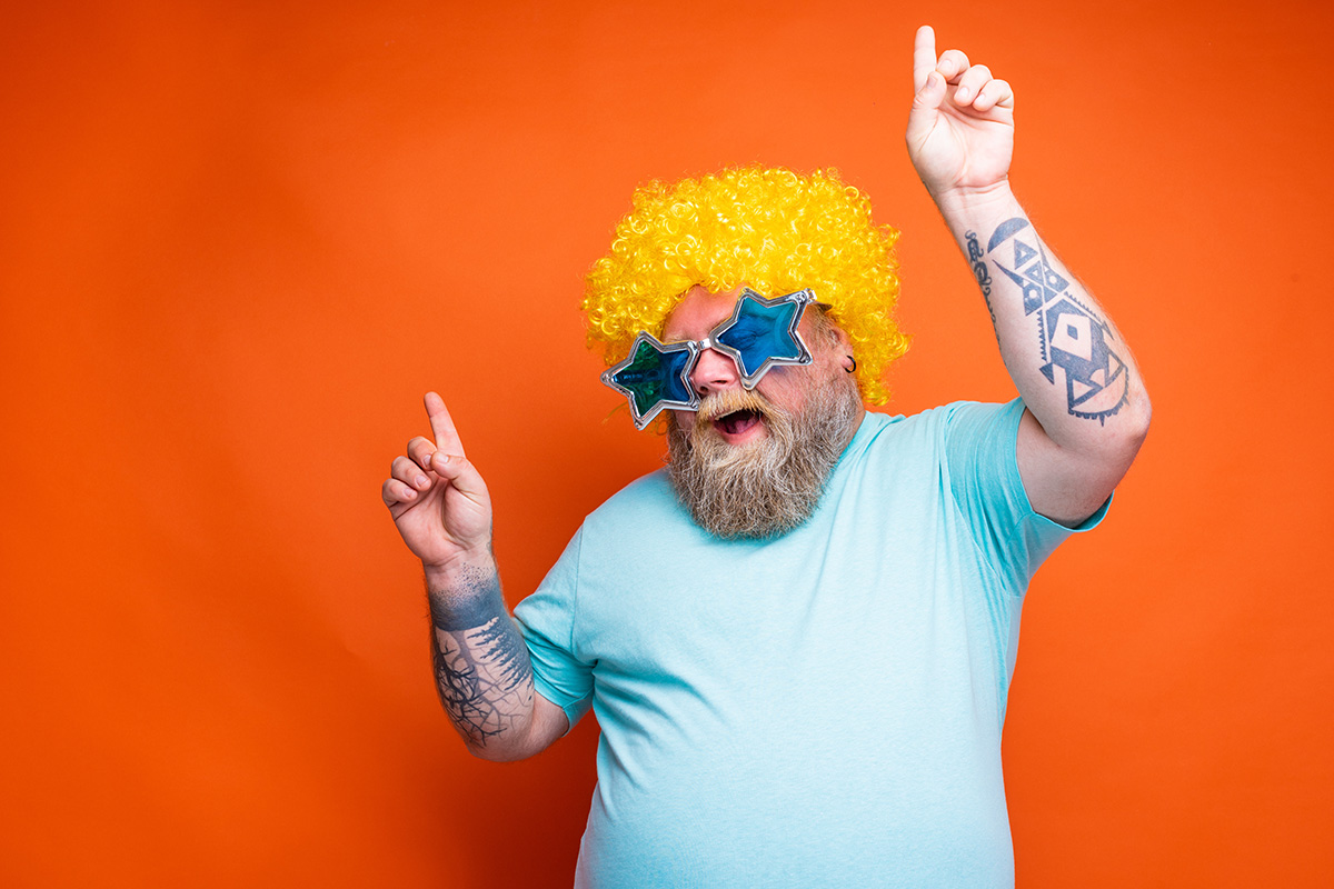 dancing man wearing yellow afro wig and blue star-shaped glasses