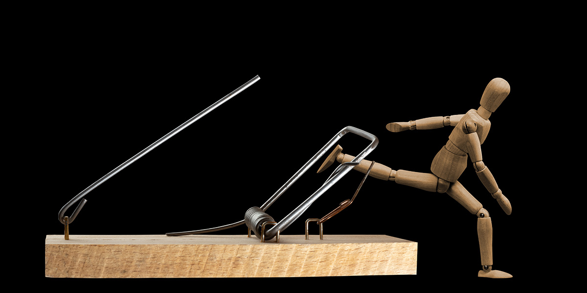 wooden mannequin caught in mouse trap