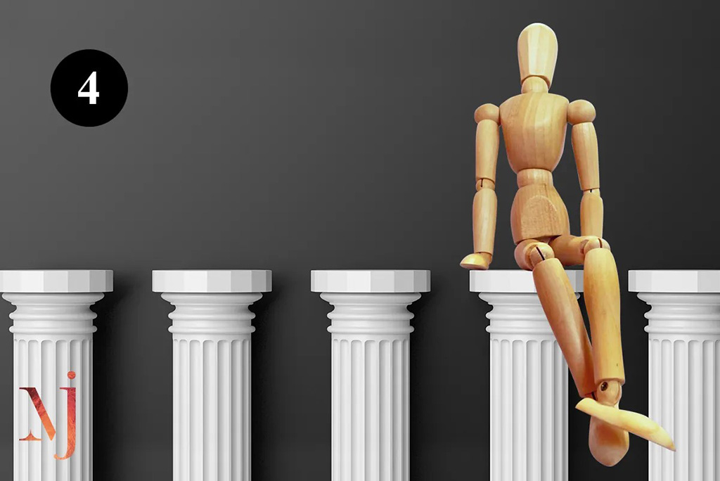 wooden mannequin sitting on top of pillar