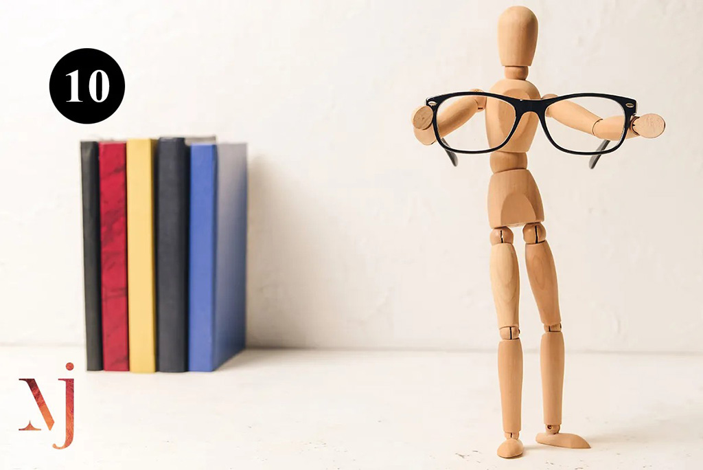 wooden mannequin holding a pair of glasses