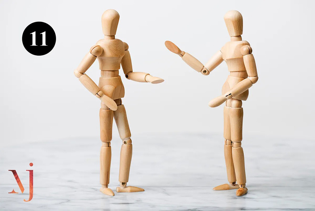 pair of wooden mannequins talking to each other