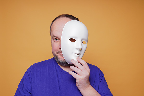 man hiding behind white mask