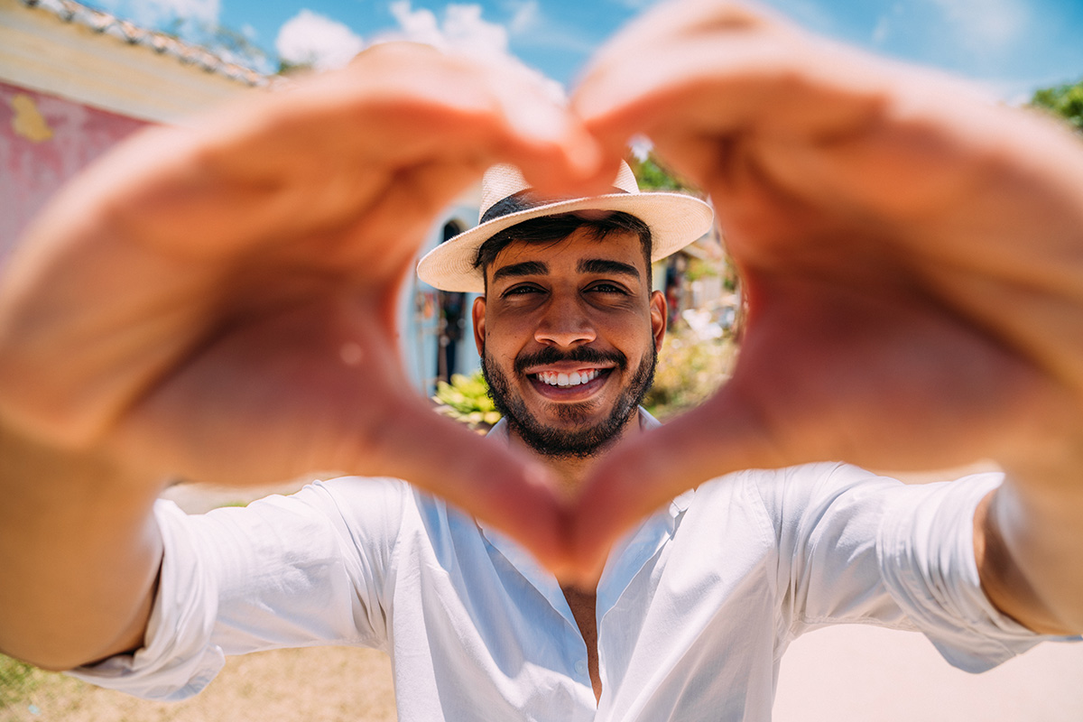 man forming a heart with his hands