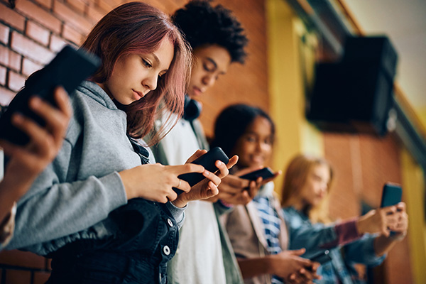 line of teenagers looking at their smartphones