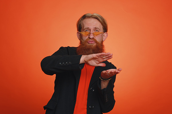 red headed man dressed in funky suit making money swiping motion with his hands