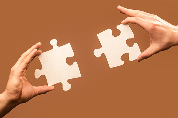 two people putting puzzle pieces together