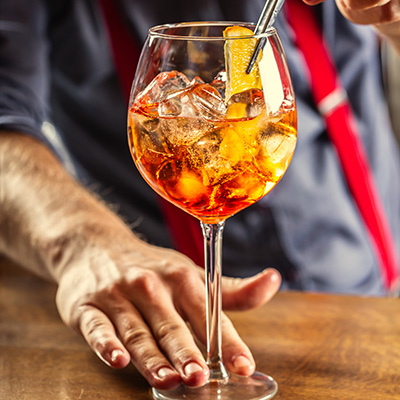 aperol spritz cocktail being served by a bartender