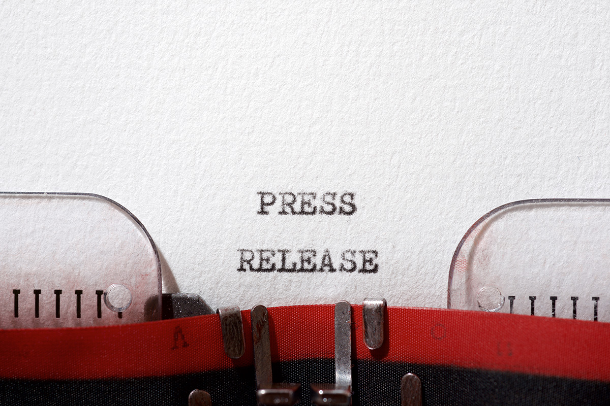 Typewriter typing "press release" on paper